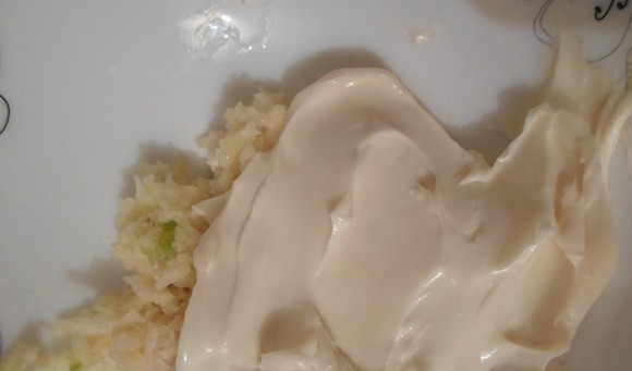 1. Этап. Обжаренный лаваш с крабовыми палочками: К плавленному сыру добавьте пропущенный через чеснокодавилку чеснок. Отправьте смесь в микроволновку на 10 секунд для размягчения.