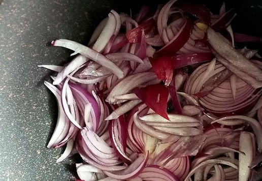 1. Этап. Луковый мармелад на красном вине: В посуду с толстым дном наливаем масло, ставим на огонь и выкладываем лук. Обжариваем до мягкости 5 минут примерно на среднем огне, помешивая.