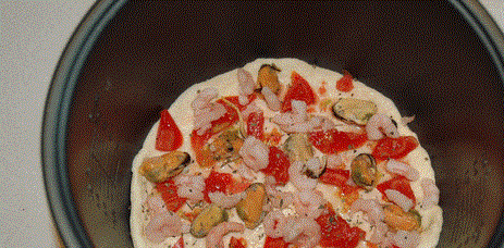 1. Этап. Пицца с креветками в мультиварке: Выкладываем начинку: мелко порезанный помидор и морепродукты.