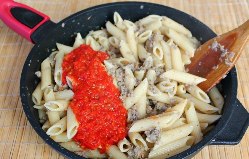 1. Этап. Макароны по-флотски на сковороде: Добавляем аджику, перемешиваем и обжариваем все вместе 1-2 минуты.