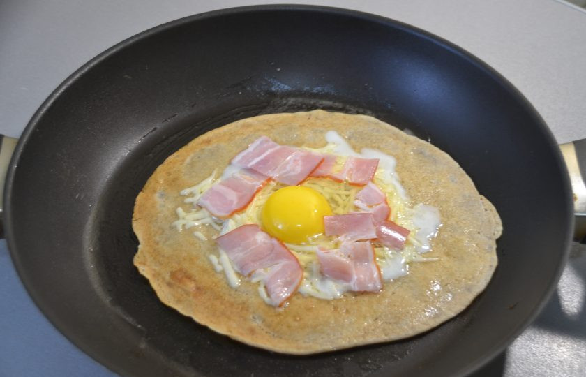 1. Этап. Яичница в блинах: Вокруг яйца выложите бекон или ветчину, затем аккуратно подверните к центру все четыре стороны блина, не забывайте посолить и поперчить.