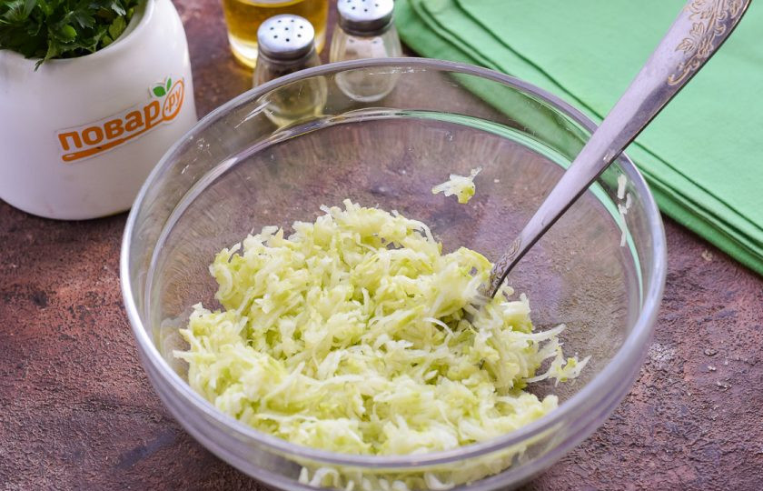 1. Этап. Оладьи из кабачков с моцареллой: Кабачок ополосните и просушите, после натрите на мелкой терке. Переложите кабачковую массу в глубокую миску.