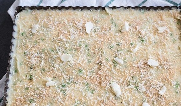 1. Этап. Картофельный пирог с зеленым горошком: 5. Выложите картофельное тесто в форму для запекания, разровняйте, посыпьте поверхность панировочными сухарями, оставшимся тертым пармезаном и положите небольшие кусочки сливочного масла.