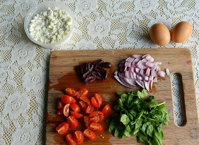 1. Этап. Омлет по-гречески: 1. Для начала необходимо подготовить все неотъемлемые составляющие. Итак, помидоры (в данном случае черри) вымыть и нарезать пополам. Очистить луковицу и нарезать кубиками. Оливки нарезать четвертинками или половинками. Шпинат (рецепт приготовления омлета по-гречески не ограничивается только этой зеленью, можно выбрать любую, которая есть под рукой) вымыть, просушить и немного измельчить.