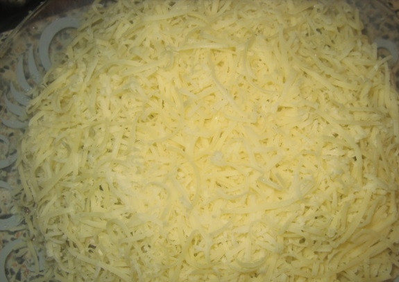 1. Этап. Салат Санта Клаус: После этого смажьте слой майонезом. Выложите огурцы и натрите сыр.