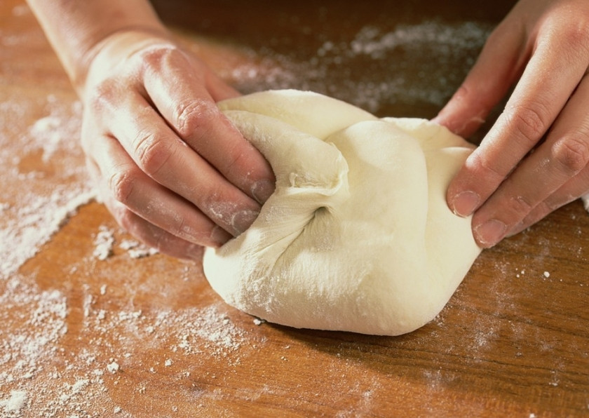 1. Этап. Тесто для пельменей на минералке: 4. Затем доводим его до нужного состояния руками. Для этого насыпьте на дощечку немного муки (чтобы тесто не прилипало) и замешивайте до тех пор, пока тесто не перестанет браться к рукам.