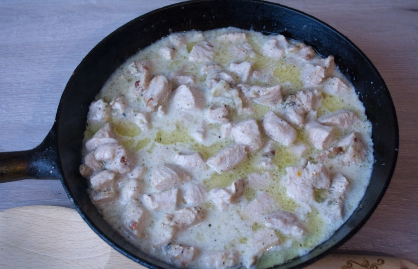 1. Этап. Индейка под сливочным соусом: Влейте подготовленный сливочный соус к индейке в сковороду. Перемешайте. Тушите под крышкой на маленьком огне около 5 минут.