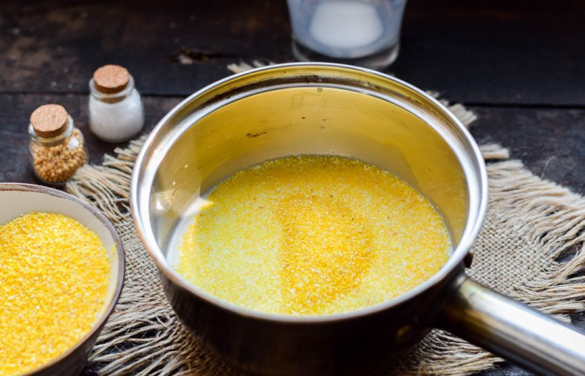 1. Этап. Кукурузная каша на молоке для ребенка: Всыпьте кукурузную крупу в кастрюлю. Поставьте кашу на умеренный огонь.