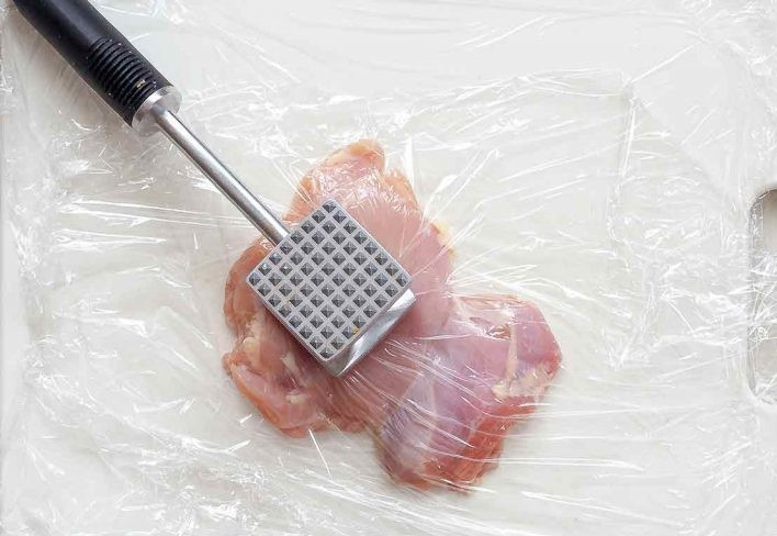 1. Этап. Куриное мясо в апельсиновом маринаде: 4. Накройте каждое бедро пленкой и немного отбейте, чтобы мясо было одинаковой толщины.