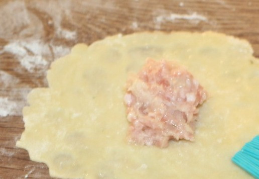 1. Этап. Вкусные ракушки с начинкой из индейки: 12. Холодные шарики раскатываем в тонкие лепешки, и кладем по чайной ложке начинки. Половинку края лепешки смазываем яичным белком.