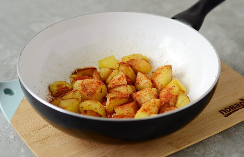 1. Этап. Пататас бравас: Присыпьте картофель паприкой и чили, перемешайте.