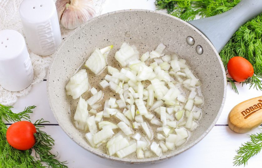 1. Этап. Минтай в капусте: Лук нарежьте мелкими кубиками и обжарьте в растительном масле на сковороде примерно 3-5 минут до румяности.