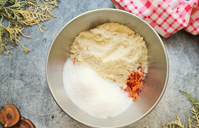 1. Этап. Морковный кекс с творожным сыром: Добавьте к моркови сахар, миндальную муку и перемешайте.