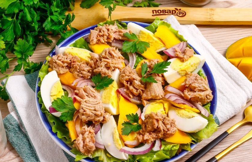 1. Этап. Салат с тунцом и манго: Вскройте банку с тунцом и выложите рыбную мякоть на остальные ингредиенты. Посолите, по желанию — поперчите.