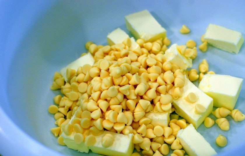 1. Этап. Выпечка с белым шоколадом: 1. Первым делом выложите в миску 1,5 стакана шоколадных чипсов, добавьте сливочное масло и отправьте в микроволновую печь на 2 минуты, каждые 30 секунд доставайте массу и перемешивайте лопаткой.