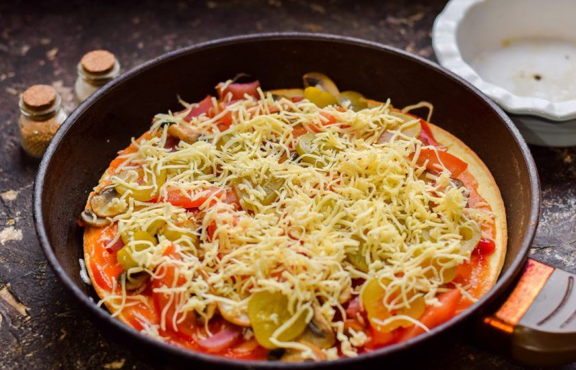 1. Этап. Пицца с грибами на сковороде: Посыпьте заготовку сыром, готовьте пиццу под крышкой 15 минут.