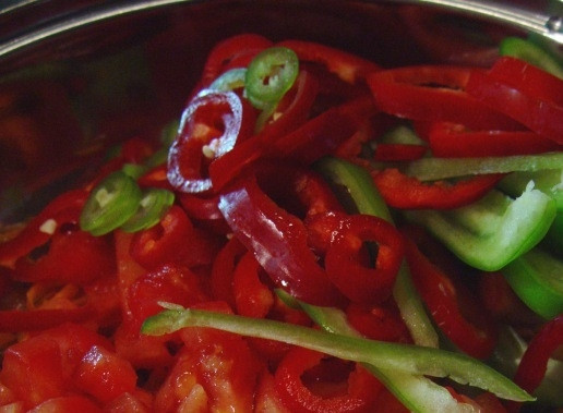 1. Этап. Масляная рыба, тушенная с овощами: 5. Добавьте кубики помидоров, перец, чуть подсолите. Томите на среднем огне 2-3 минуты.