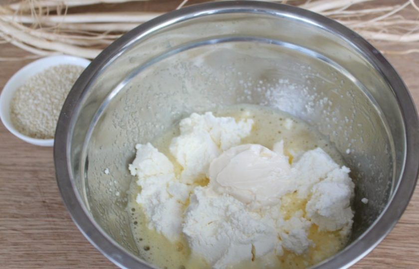 1. Этап. Кунжутное печенье с творогом: Добавляем творог и сливки. Жирные сливки можно заменить кусочком растопленного сливочного масла.