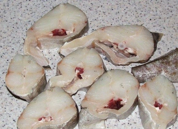 1. Этап. Треска, тушенная в сметане: Если вы используете замороженную треску, ее нужно предварительно разморозить. Затем очистите рыбу от внутренностей, пленочек, плавников и нарежьте на порционные кусочки. Толщину можете выбрать ту, которая вам нравится. Я режу на куски по 3-4 сантиметра.