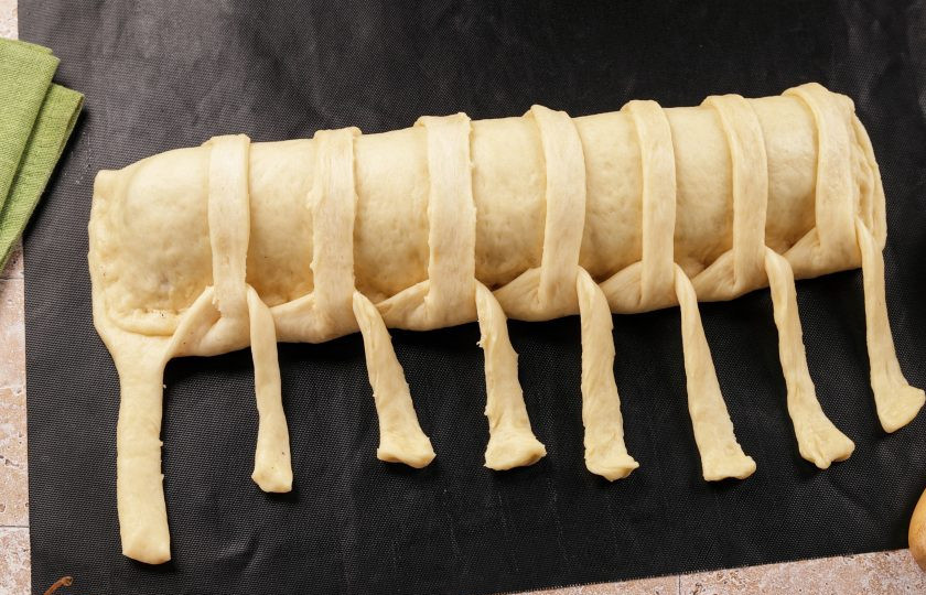 1. Этап. Пирог на дрожжах с яблоками: Начиная с первой полоски, делайте сплетения. Первую полоску теста подведите под низ следующей и перебросьте на рулет. Со следующей полоской поступите так же, и так до конца.