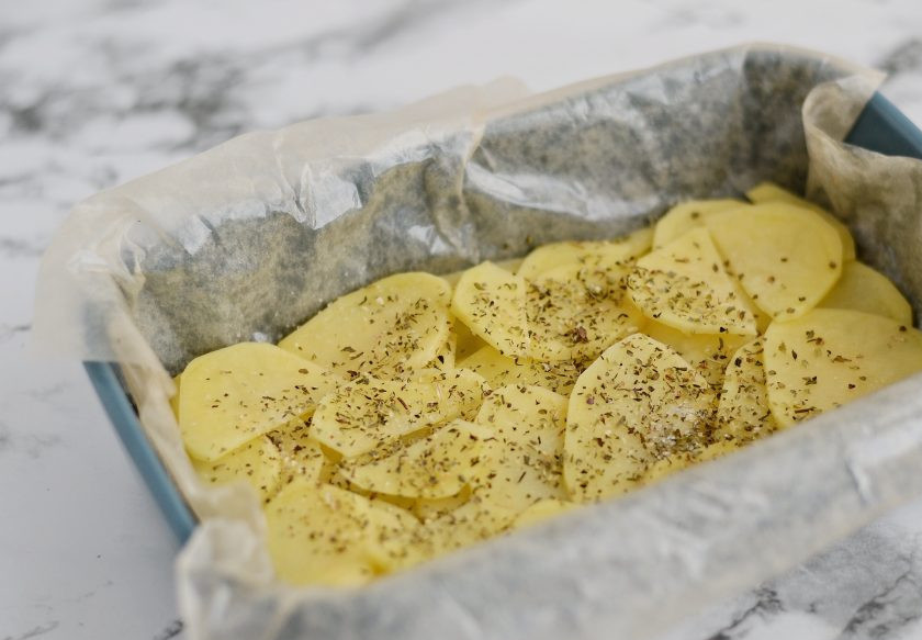 1. Этап. Запеканка с бататом: На дно формы выложите кружочки картофеля в 1-2 слоя. Посолите и посыпьте итальянскими травами.