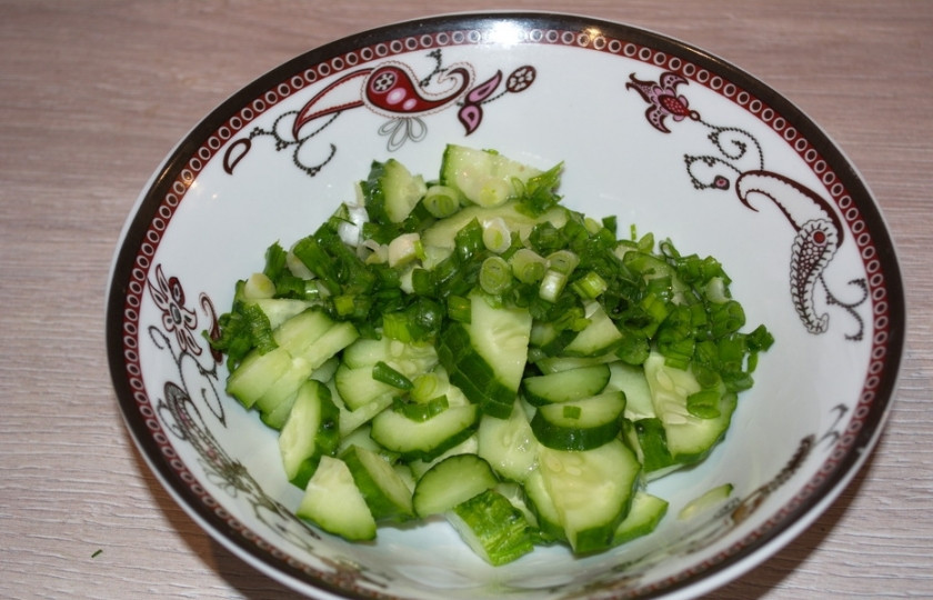 1. Этап. Огурцы кусочками в собственном соку: Переместите нарезанные огурчики в салатник или миску. Слегка посолите. Огурцы тут же станут пускать сок. Измельчите зеленый лук и добавьте его к огурцам.