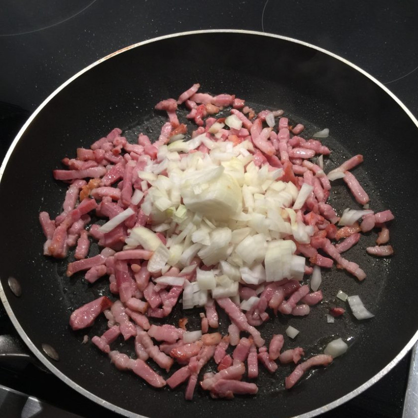 1. Этап. Спагетти с соусом Карбонара: 4. Добавьте луковицу к бекону, перемешайте и готовьте до прозрачности лука.