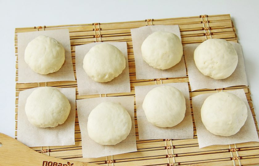 1. Этап. Маньтоу: Из каждого кусочка теста сформируйте руками шарики и выложите каждую заготовку из теста на квадратик из пергамента. Эта хитрость предотвратит прилипание булочек ко дну пароварки при термообработке. Накройте тесто чистым полотенцем и оставьте для отстойки примерно на 40 минут.