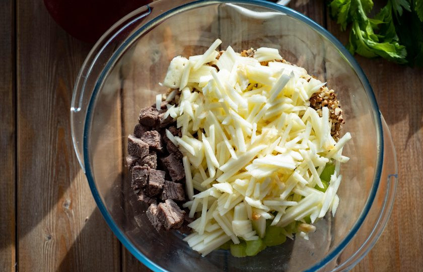 1. Этап. Салат с сельдереем и говядиной: Добавьте измельченные грецкие орехи и очищенное от кожуры яблоко, натертое на крупную терку.