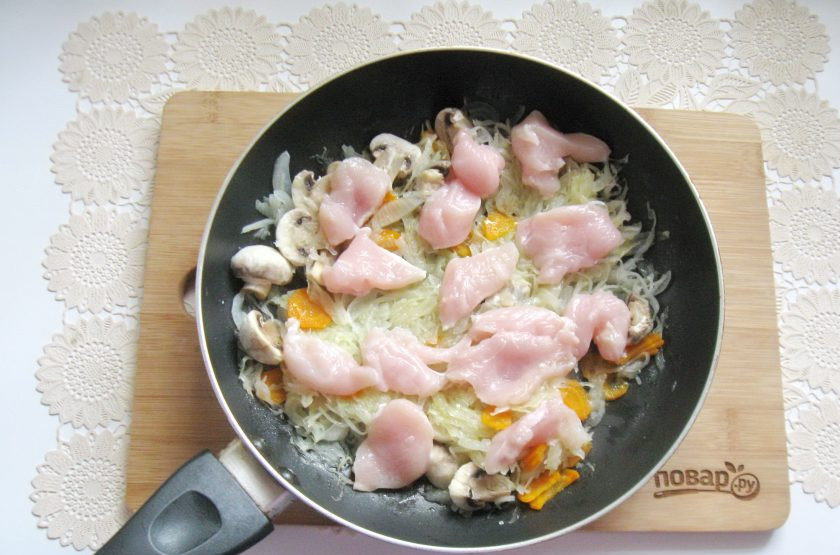1. Этап. Капуста тушеная с курицей и грибами: Куриное филе нарежьте небольшими кусочками и добавьте в сковороду с овощами и грибами. Посолите и поперчите по вкусу.