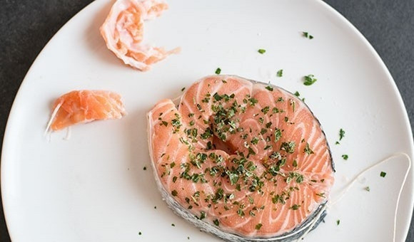 1. Этап. Лосось, запеченный с картофелем: 1. Из стейка лосося удалите кости и позвоночник в центре. Затяните ломтик рыбы кухонным шпагатом, чтобы придать ему форму медальона.