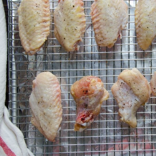 1. Этап. Острые куриные крылышки с медом: Выложите куриные части на сетку в противне с фольгой. Посыпьте их солью и перцем. Запекайте 15 минут при 200 градусах.