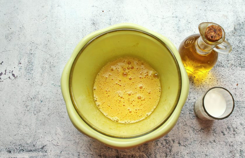 1. Этап. Пирог с вареньем Нежнее нежного: Влейте в яйца молоко и перемешайте до однородности. Затем влейте растительное масло и ещё раз перемешайте.