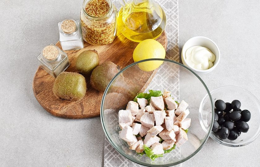 1. Этап. Салат с киви и курицей: На дно глубокой салатной миски порвите салатные листья средними кусочками. Сверху добавьте жареное куриное филе, нарезанное кубиками.