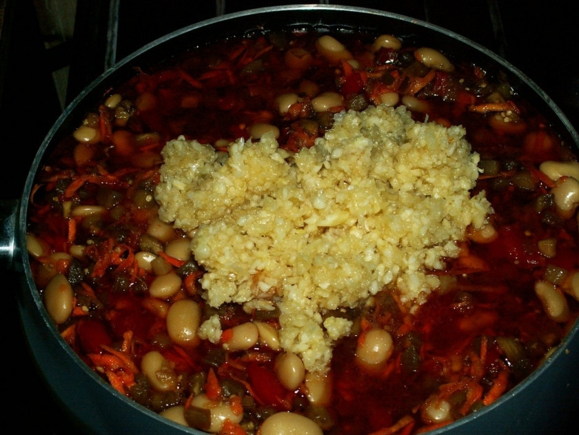 1. Этап. Фасоль консервированная на зиму: 8. Очистите чеснок и пропустите через пресс. Примерно за минут 10 до готовности добавьте к овощам чеснок и перемешайте.