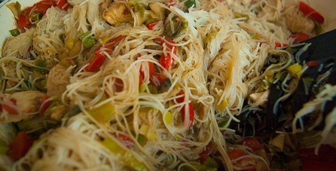 1. Этап. Рисовая лапша с овощами и курицей: Подготовленную лапшу добавьте на сковородку к овощам и курице. Присыпьте все ингредиенты перцем, посолите. Вы можете использовать любимые приправы и травы. Перемешайте содержимое сковороды, прогрейте под крышкой еще пару минут.