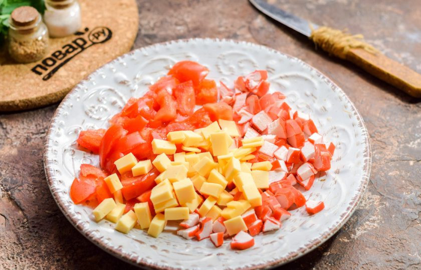 1. Этап. Салат с крабовыми палочками и маринованным луком: Твердый сыр нарежьте небольшими кубиками и добавьте к другим ингредиентам.