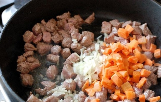 1. Этап. Говядина, тушеная с редькой: 4. После выложите измельченный лук и морковь. Обжарьте пару минут вместе с мясом.