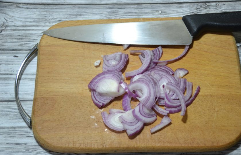1. Этап. Ялтинский салат: Порежьте половинку красного лука на четвертинки колец.