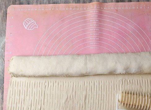 1. Этап. Пирог с тефтелями и сыром: Свернуть половину в рулет. На остальной части теста сделать сеточку, с помощью специального ролика.