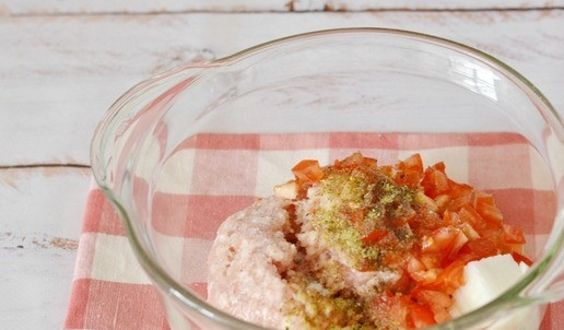 1. Этап. Запеканка из куриного фарша с вермишелью: Нарежьте мелко лук и помидор, добавьте их к куриному фаршу. Приправьте по вкусу солью, перцем и специями для птицы. Всё смешайте.