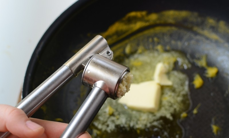 1. Этап. Морковный суп-пюре с имбирем: Если желаете сделать тосты, на сковороду положите масло, выдавите чеснок и поджарьте хлеб.