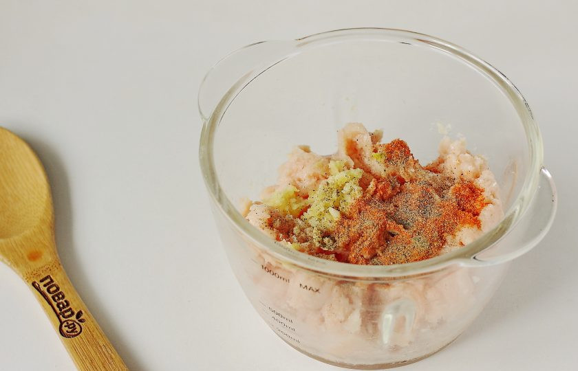 1. Этап. Куриная запеканка ПП: Добавьте к фаршу пропущенный через пресс чеснок, соль по вкусу и специи.