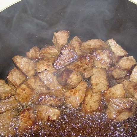 1. Этап. Говядина с черносливом: Параллельно этому разогреваем в другой посуде еще немного масла и обжариваем в нем кусочки говядины размером примерно 3 на 3 см. Обжариваем на очень быстром огне - нам нужно, чтобы мясо покрылось корочкой. Чтобы мясо именно жарилось, а не тушилось в собственном соку, обжаривать нужно небольшими партиями - у меня было 3 захода.