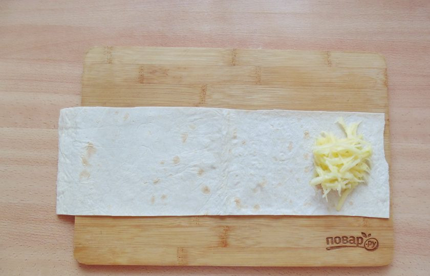 1. Этап. Ленивые пирожки с яблоками: На край полоски из лаваша выложите тертые яблоки.