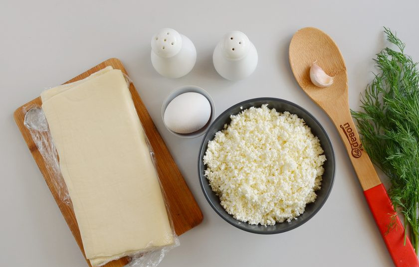 1. Этап. Слоеные конвертики с творогом: Подготовьте ингредиенты. Заранее достаньте тесто из морозилки, чтобы оно полностью было готово к выпечке. Включите духовку на 190 градусов.