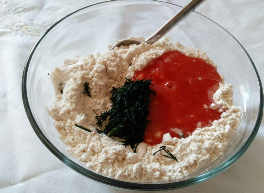 1. Этап. Закусочные томатные панкейки: Всыпьте зелень в сухую смесь, влейте томатный сок, хорошо перемешайте и добавьте подсолнечное масло.