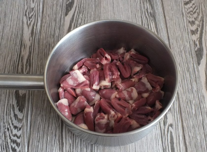 1. Этап. Куриные сердечки по-корейски: Куриные сердечки промойте, разрежьте на две половинки. Залейте водой и поставьте на огонь. Варите в течение 40 минут. Через 20 минут после закипания посолите.