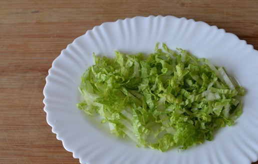 1. Этап. Салат Княжий град: Берём плоское блюдо, кладём нижним слоем половину количества шинкованной пекинской капусты.