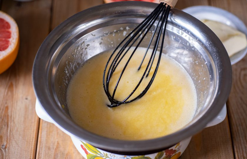 1. Этап. Грейпфрутовый курд: В небольшую кастрюльку залейте немного воды и поставьте на средний огонь. Установите на кастрюльку с водой миску с яичной смесью. Варите смесь на водяной бане, постоянно помешивая венчиком, до заметного загустевания.